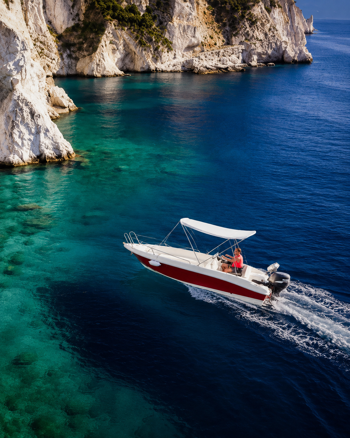 A luxury speedboat cruising along the white cliffs of Paleokastritsa, Corfu